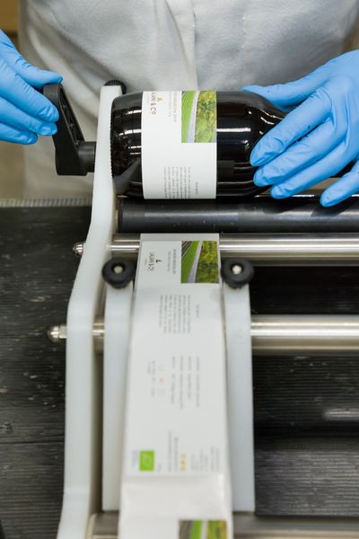 Labelling is at the heart of food safety a person wearing blue gloves and labelling a product