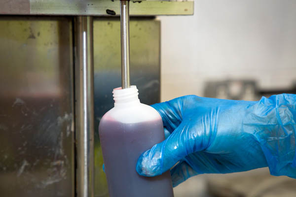 a hand filling liquid with a machine