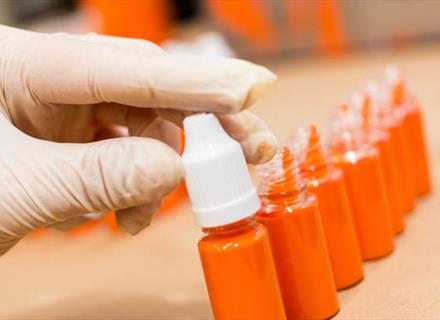 a hand with a glove on assembling a product by twisting the lid on