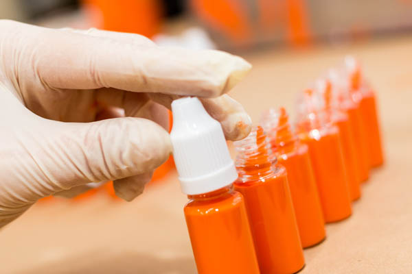 a row of products with a hand assembling the closest bottle