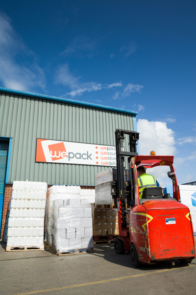 A man in a forklift in front of an order of products